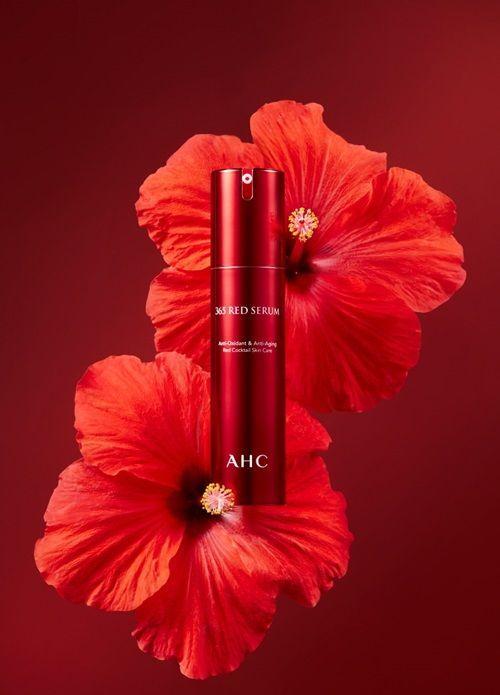 AHC 365 Red Serum displayed against vivid red floral backdrop emphasizing antioxidant benefits.